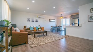 A modern living room with a sofa, coffee table, and dining area. - New 20% discount - Backyard PARADISE - JT Escape w/ Hot Tub (Joshua Tree)