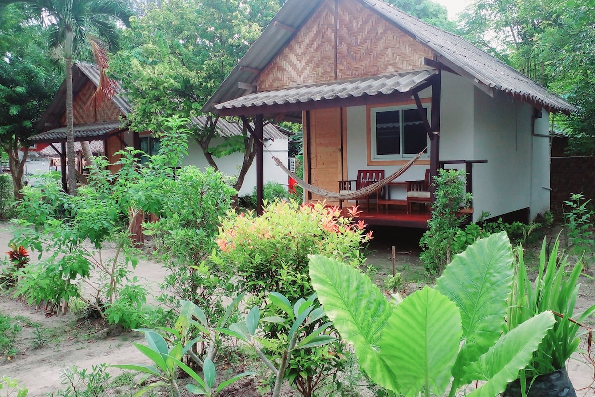 A traditional wooden house with a porch and a hammock.
