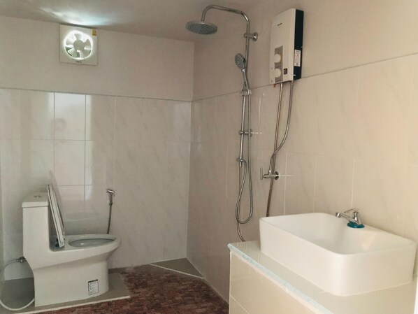 Een badkamer met toilet, douche en bad.