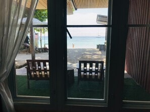 A view through a window with a wooden bench outside, a railing, and a clear sky. - Lipe Garden Beach Resort (Koh Lipe)