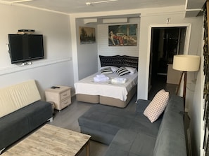 A modern hotel room with a bed, a sofa, a TV, and a painting on the wall. - antik sofia hotel (Istanbul)