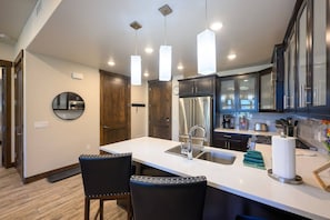 A modern kitchen with a central island, stainless steel appliances, and pendant lighting.