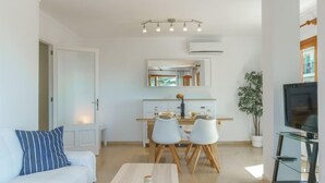 A modern living room with a sofa, a dining table, and a TV. - Can Llorenc Sea Views by Interhome (Port d'Alcúdia)