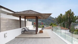 A modern rooftop terrace with a pergola, lounge chairs, and a glass railing overlooking a scenic hillside. - Miami-Style 2BR Pool Villa Janine Kamala (Kamala)