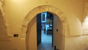 An arched doorway leading to a dining area with a table and chairs.