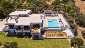 Vista aérea de una extensa propiedad con piscina, varias habitaciones para huéspedes y jardines ajardinados.