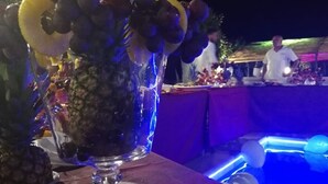 A glass with fruits and a poolside setting.