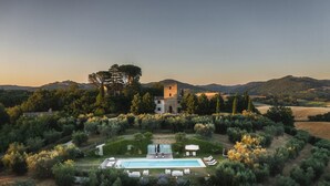 Una villa con piscina, immersa nel verde e affiancata da un’antica torre.