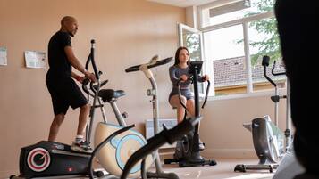 Un gimnasio con bicicletas estáticas y una cinta de correr.