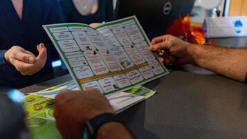 Une personne tenant un jeu de société, sur lequel on peut voir différentes options de jeu.