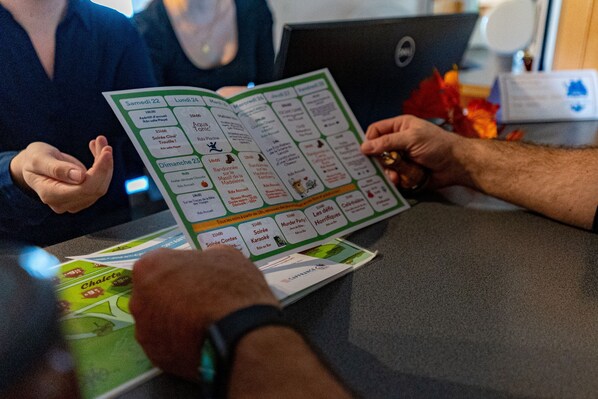 A person holding a board game with various game options visible. - Village de vacances La Bolle (Saint-Die)