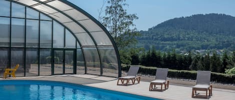 Piscine intérieure, piscine extérieure en saison, chaises longues