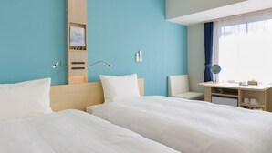 Une chambre d’hôtel avec deux lits, un bureau, une chaise, un miroir et une fenêtre avec des rideaux.