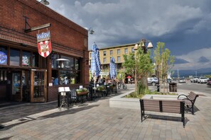 A brick building with outdoor seating and a sign reading "Barber Shop."