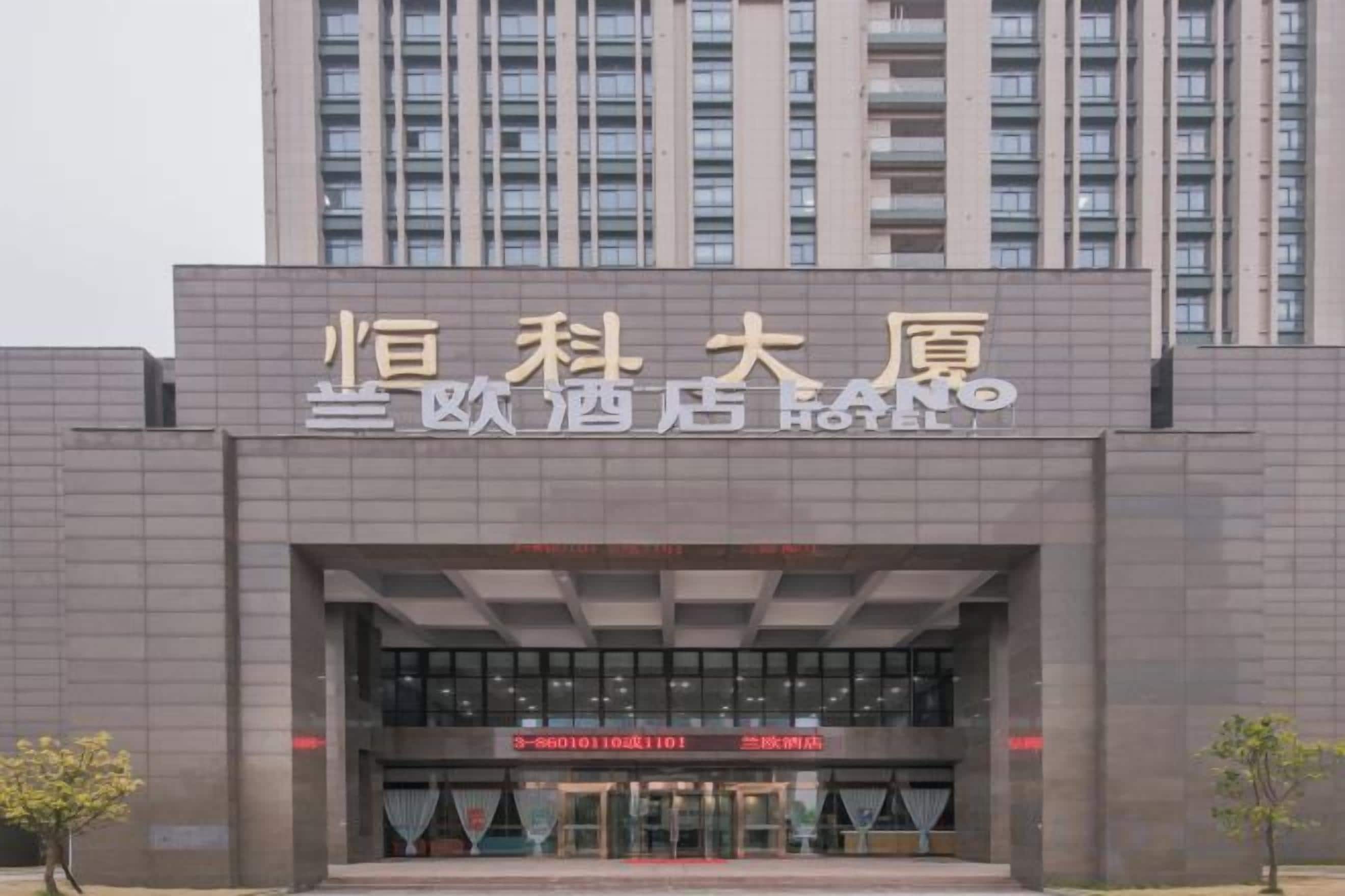 L’entrée d’un hôtel, avec une grande enseigne et une façade de bâtiment moderne.