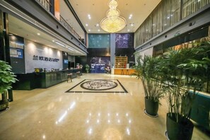 A hotel lobby with a reception desk, a chandelier, and potted plants. - LANOU Hotel (Haiyan Science City) (Haiyan)