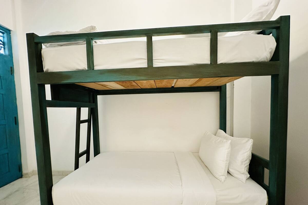 Een stapelbed met witte beddengoed en een houten frame.