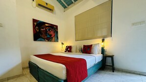 A bedroom with a bed, a painting, a nightstand, and a ceiling fan. - Moi Galle Fort by DBI (Galle)