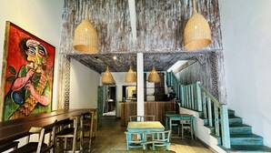 A rustic interior with wooden furniture, a staircase, and hanging wicker lamps. - Moi Galle Fort by DBI (Galle)