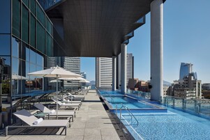 Una piscina al aire libre de temporada, camas de piscina con cargo