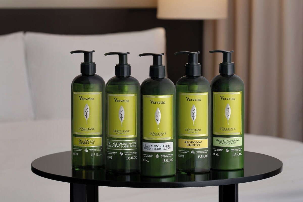 Five bottles of Verveine products on a round table in a hotel room.