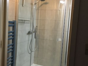 A shower with a glass door, a metal showerhead, and a blue towel rack. - Comfortable duplex, ski-in/ski-out, 6 ppl, southwest balcony (Les Arcs 1800)