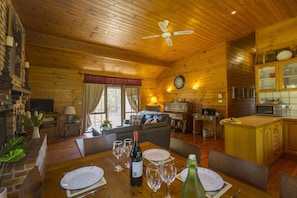 Un intérieur de chalet chaleureux comprenant un coin repas, une cuisine et un salon.