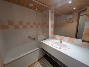 Un bagno con una vasca, un lavandino e uno specchio.