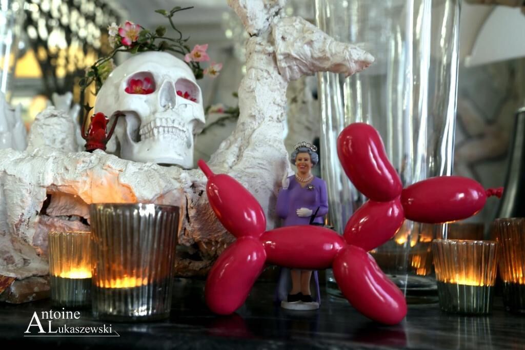 Un arreglo decorativo con una calavera, una escultura de globo rojo y una pequeña figurita.