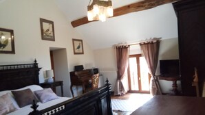 A bedroom with a wooden bed, a desk, a chair, and a television. - Maison DE Campagne AU Calme à 25 min de Provins (Soligny-les-Étangs)