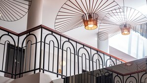 A modern interior with a staircase, metal railings, and pendant lighting fixtures. - Monocolo Boutique Hotel (Kota Kinabalu)