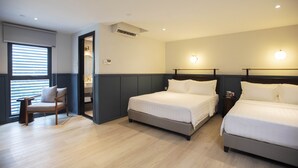 A hotel room with two beds, a chair, and a small table. - Monocolo Boutique Hotel (Kota Kinabalu)