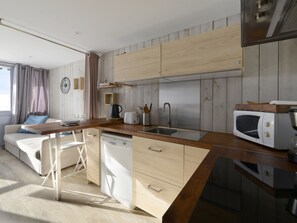 A modern kitchen with wooden cabinets, a dishwasher, a sink, and a microwave.