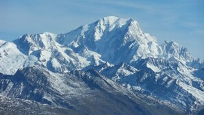 Une chaîne de montagnes enneigée, aux pics escarpés, sous un ciel dégagé.