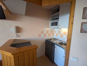 A compact kitchen with a microwave, a sink, and a dishwasher.