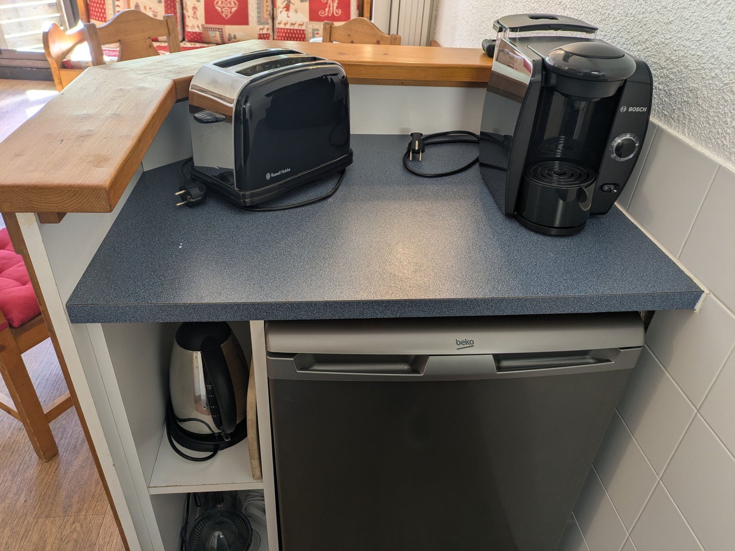 Una kitchenette equipada con tostadora, cafetera y lavavajillas.