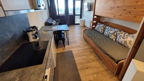 A compact living space with a kitchenette, a sofa, and a dining area.