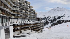 A multi-story hotel with balconies and a ski slope in the background. - Cozy studio with direct slope access, slope view, pets allowed (Plagne Aime 2000)