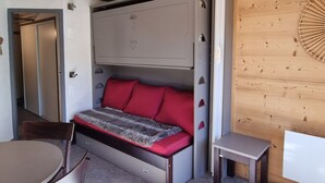 A compact room with a bed, a small table, and a chair. - Cozy studio with direct slope access, slope view, pets allowed (Plagne Aime 2000)