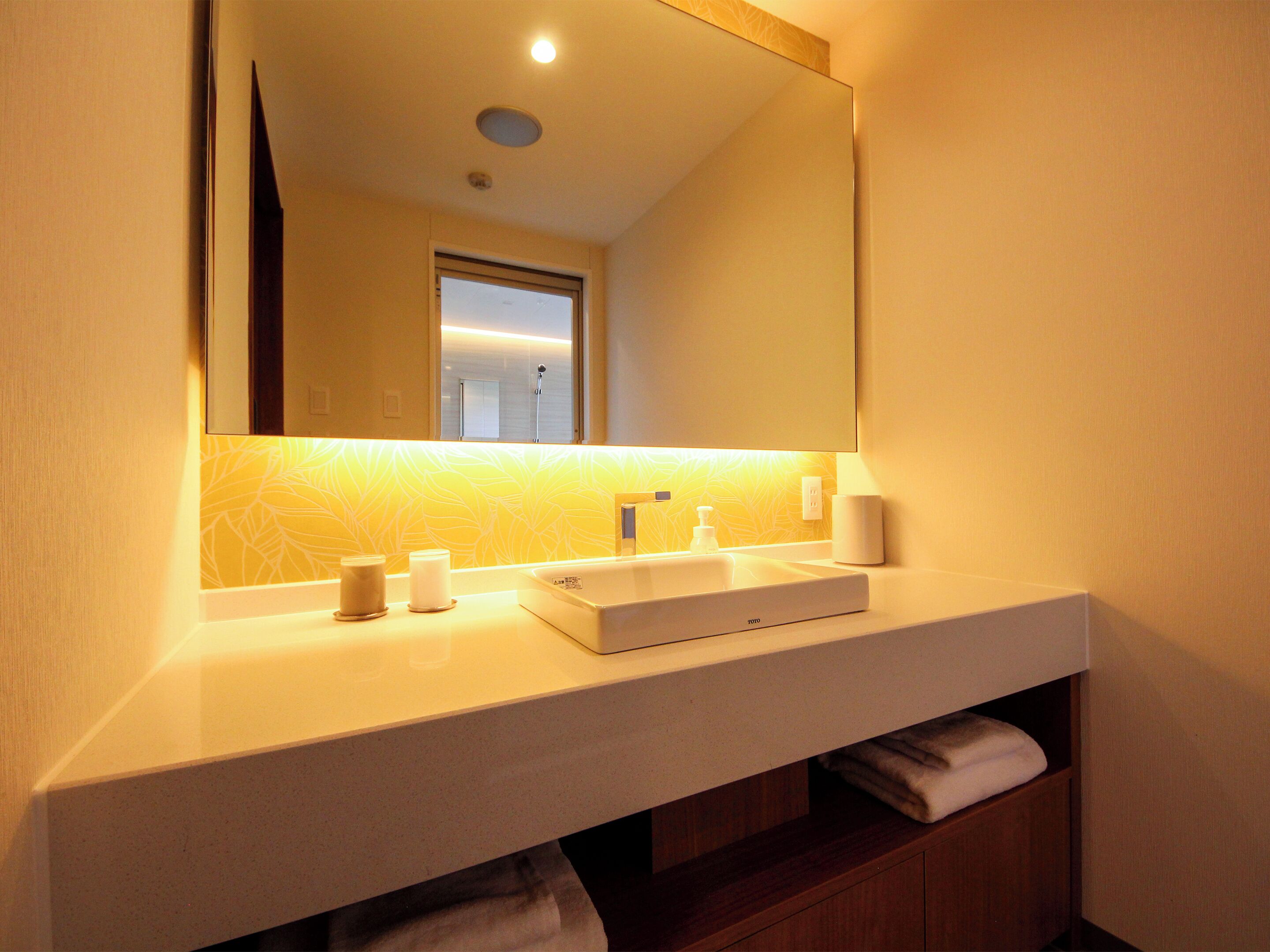 A bathroom with a white sink, mirror, and a towel rack.