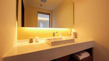 A bathroom with a white sink, mirror, and a towel rack.
