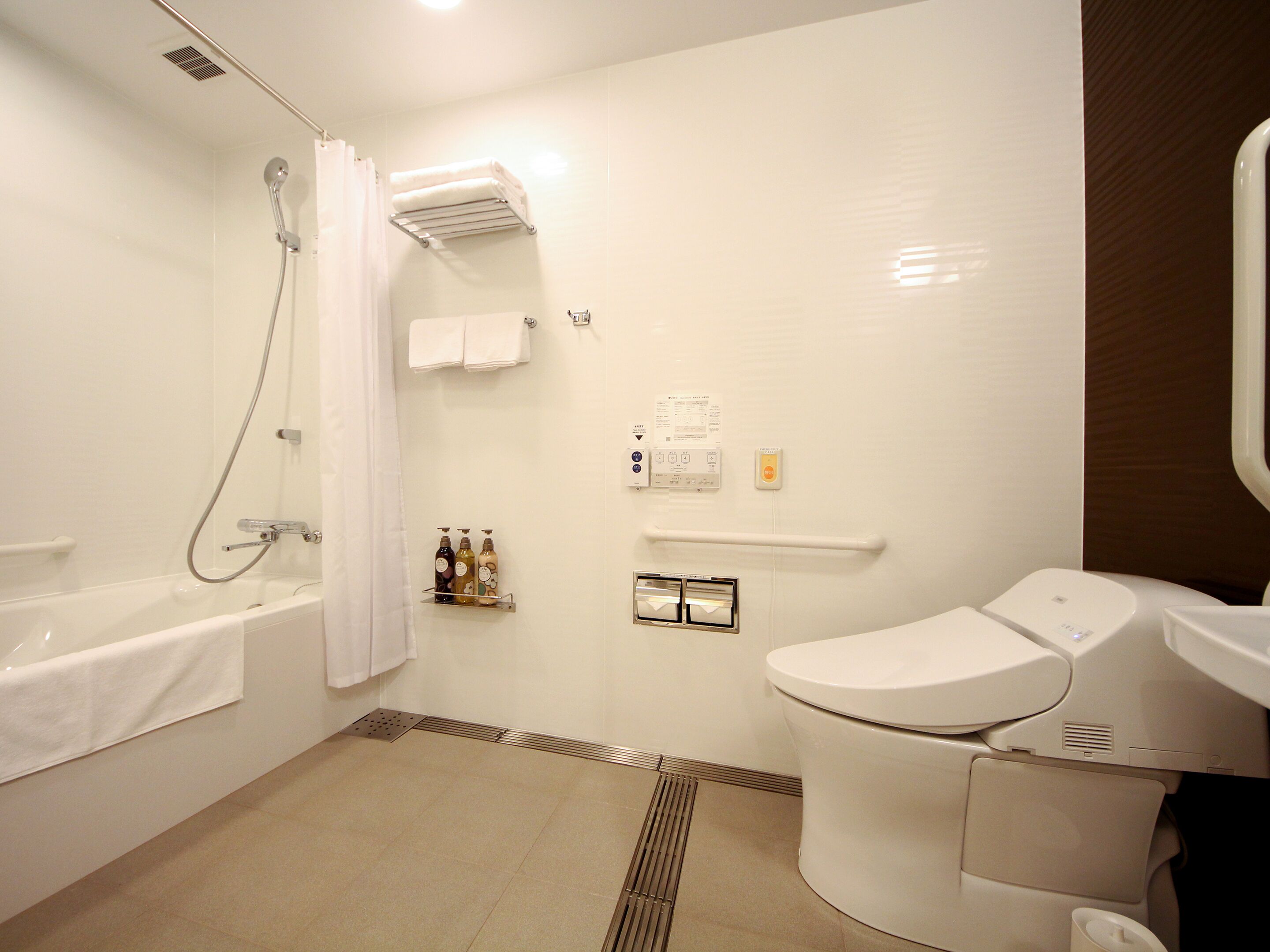 A modern bathroom with a bathtub, toilet, and shower.