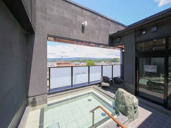 A rooftop pool with a view of a cityscape, a stone sculpture, and a sign with Japanese text. - Hotel and Spa Gift TAKAYAMA (Takayama)