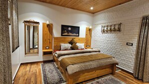 Un dormitorio con cama de madera, una pintura de cielo nocturno, pared de ladrillo y techo de madera.