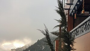 Un balcón cubierto de nieve con vistas a un paisaje montañoso.