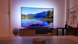 A television on a wooden stand with a scenic landscape on the screen.