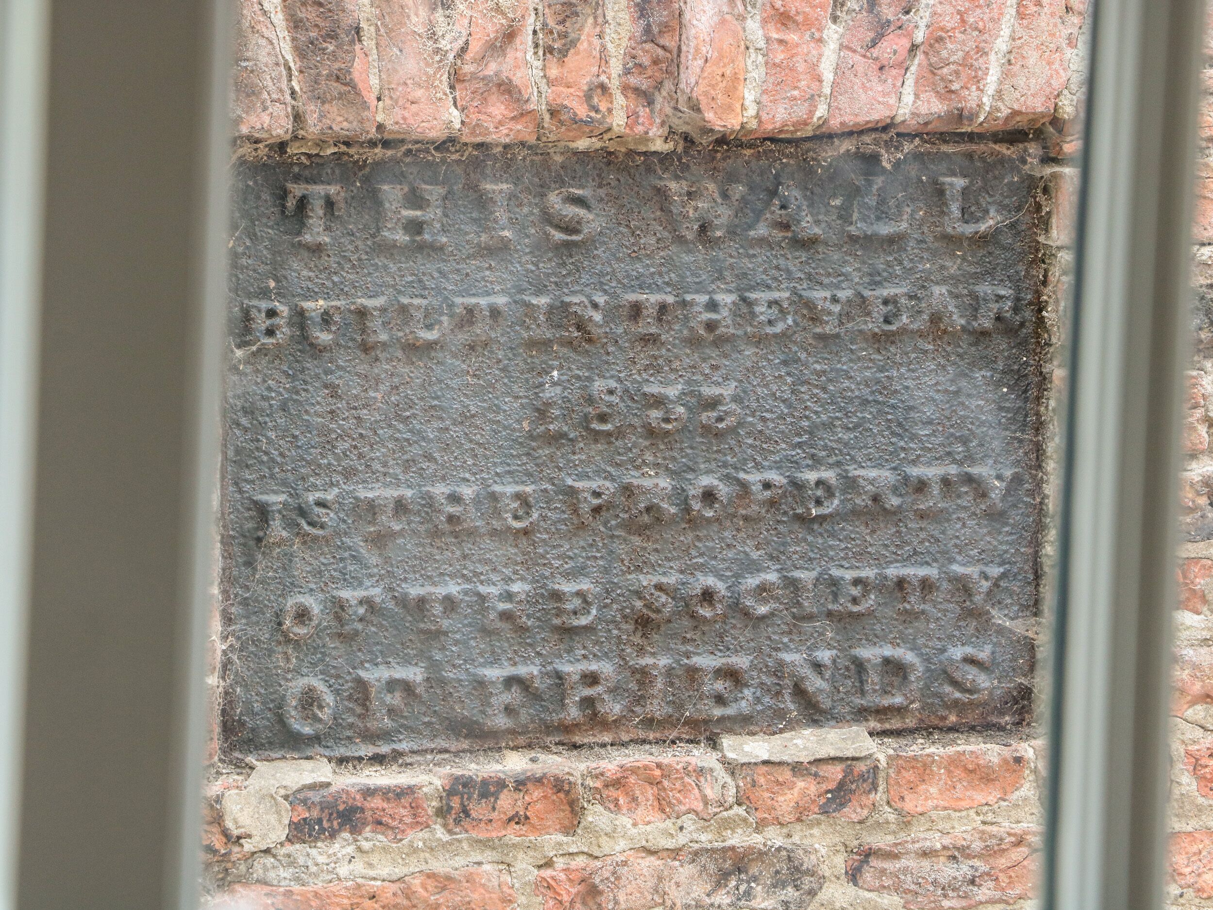 A brick wall with an inscription.