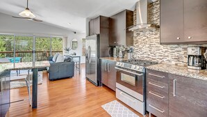 Una cocina moderna con una isla grande, electrodomésticos de acero inoxidable y vistas al exterior.