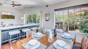 Una cocina moderna con comedor, ventanas amplias y vistas al exterior.