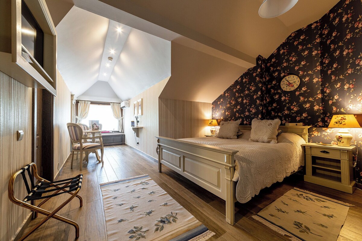 A bedroom with a bed, bedside tables, a chair, and a window.